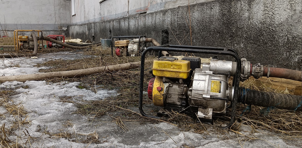 Откачка мотопомпами талой воды из подвала дома в Владивостоке